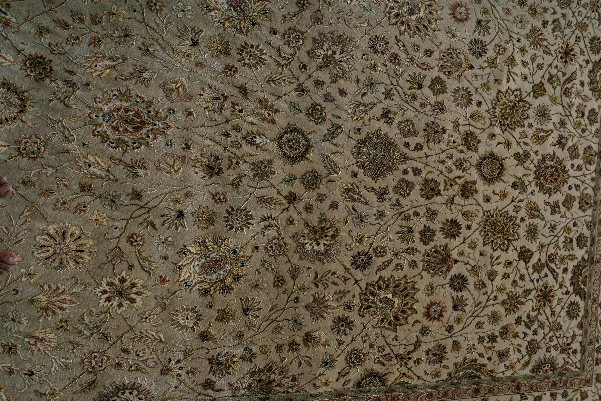 Close view of the pile of an ivory wool and silk rug