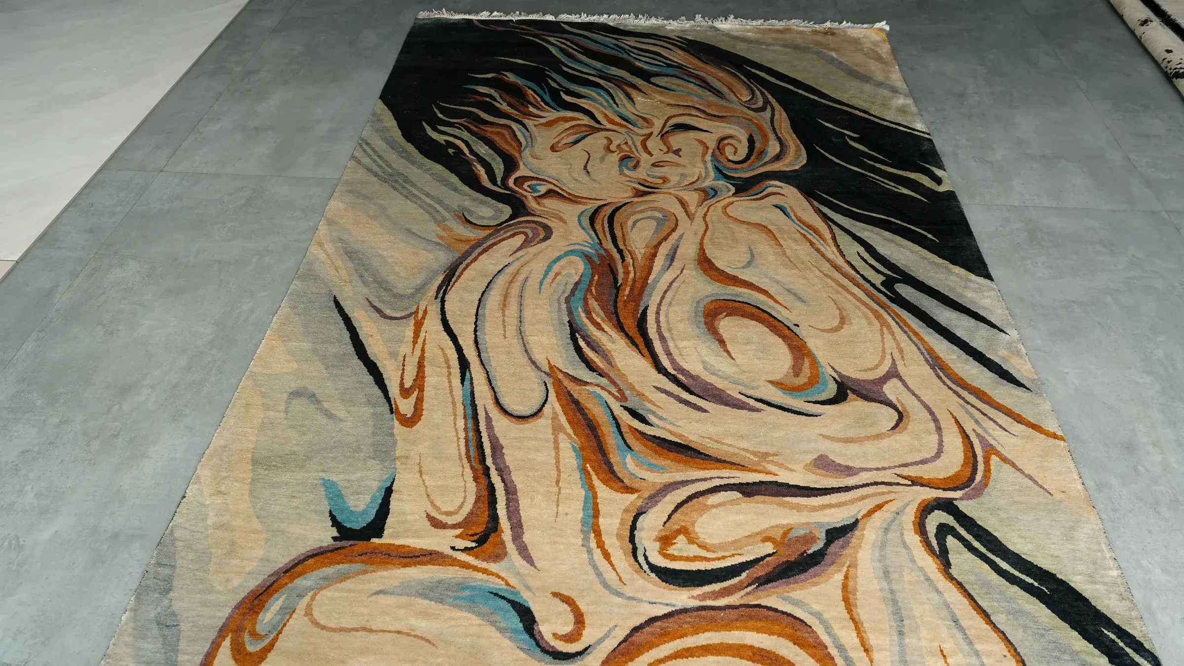Figurative silk rug laid on a concrete floor