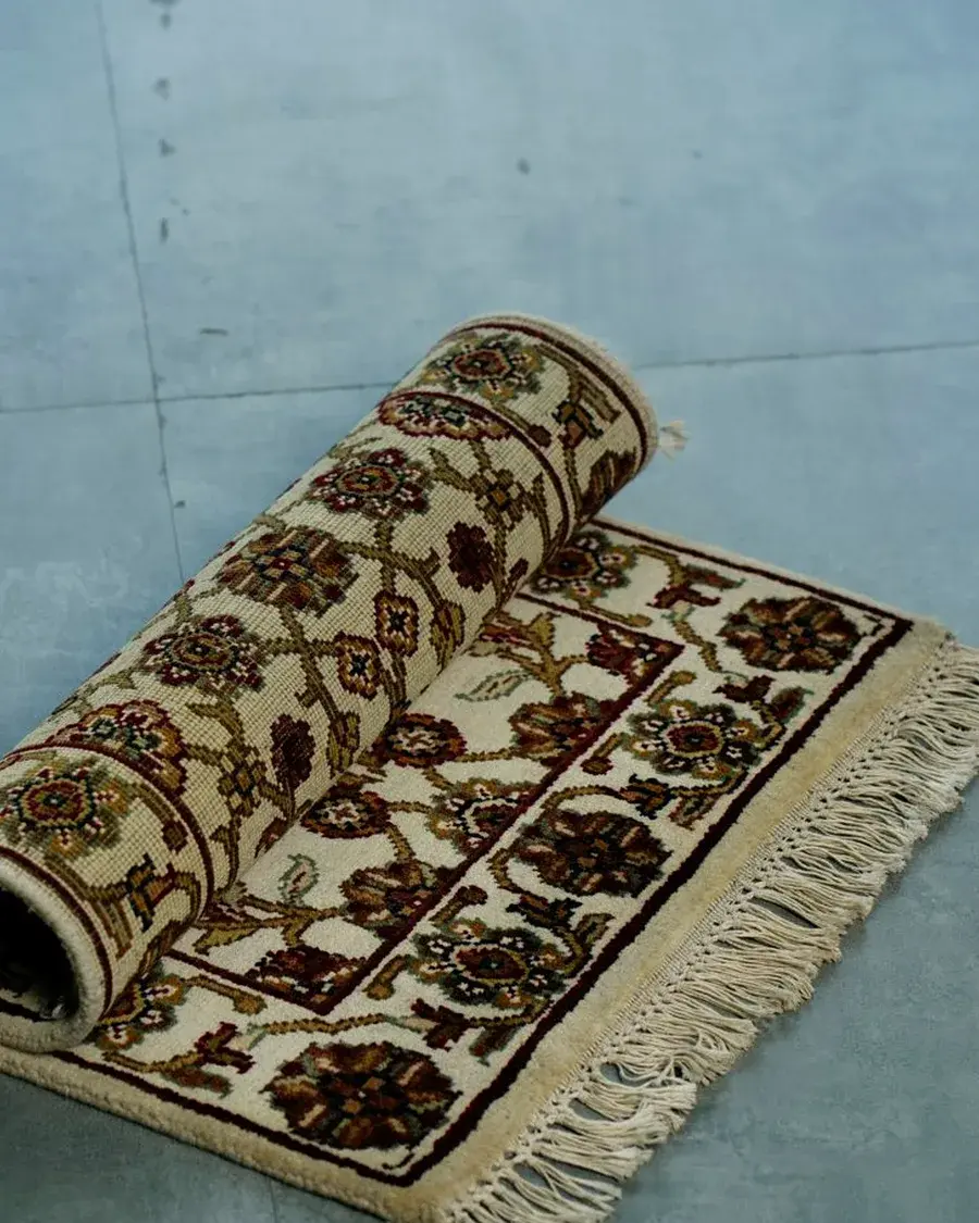 Hand-knotted rug rolled at one end