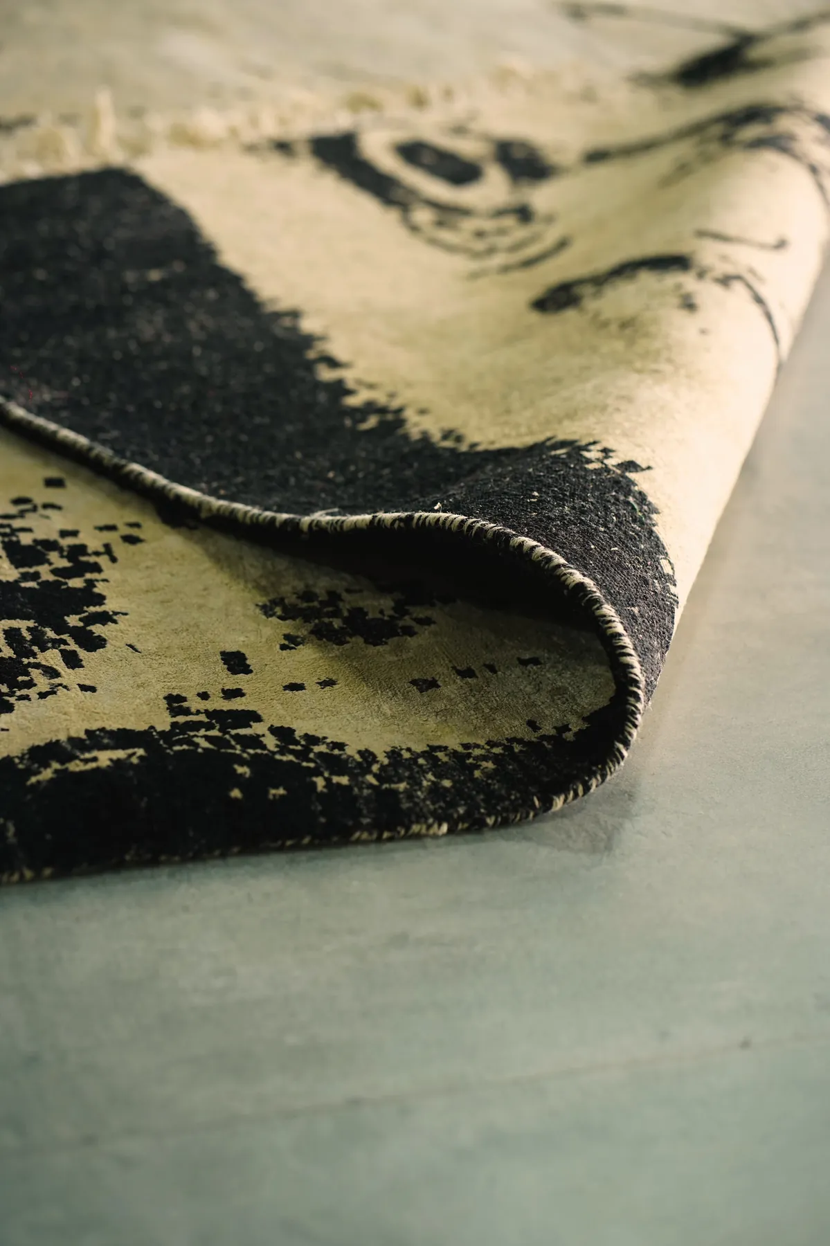 Kesha, a black and bone white Shallymar rug turned over at the corner
