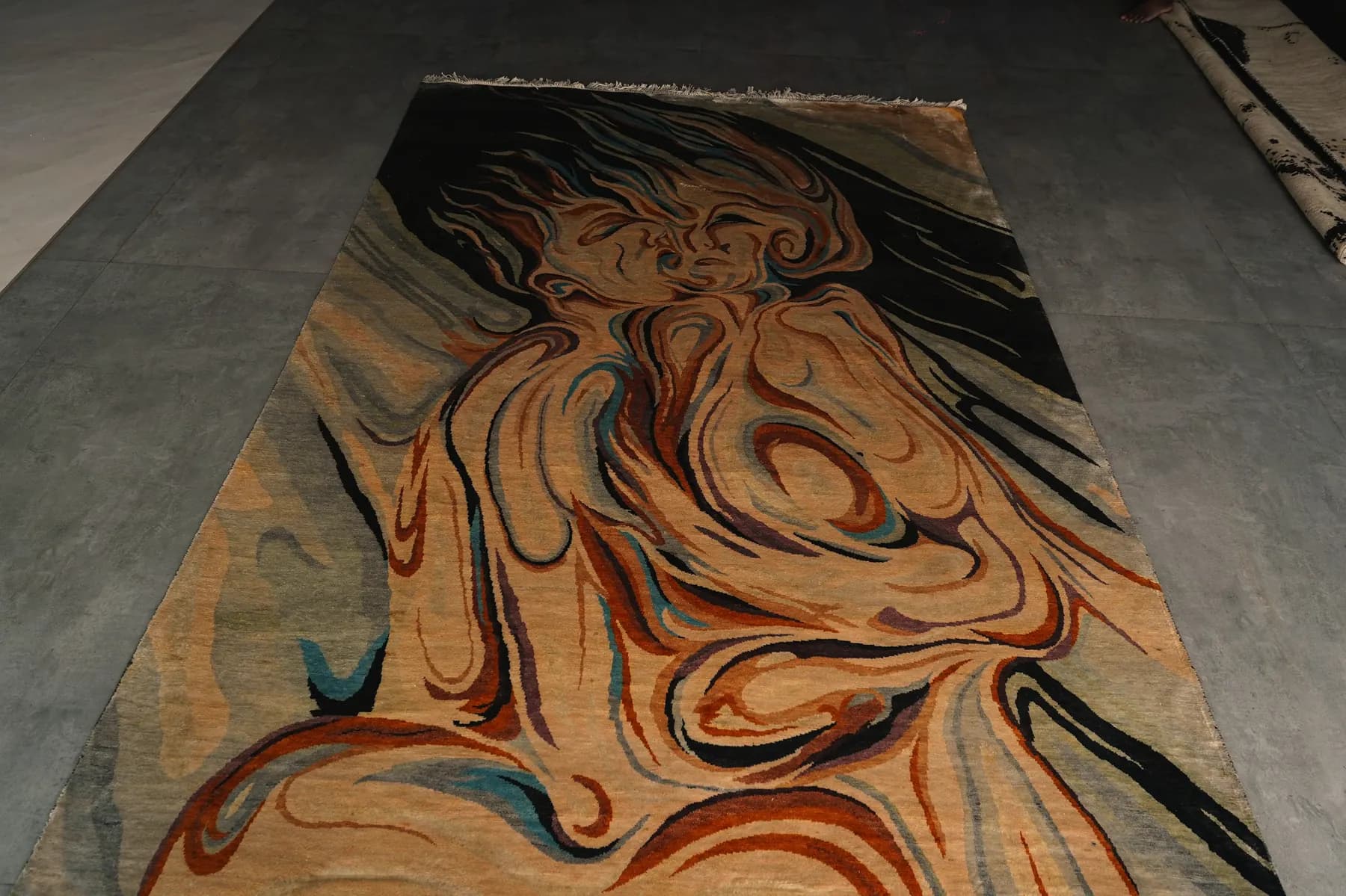 Raga, a Shallymar rug of a face in ochre and ink, seen low across the pile