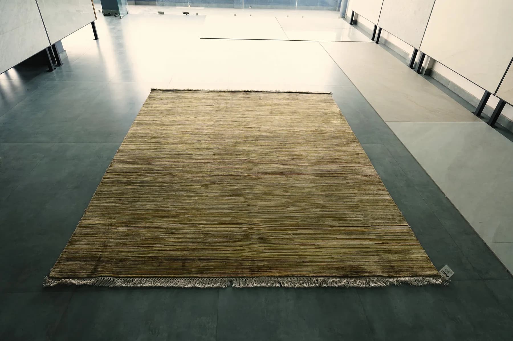 Sugandha, an olive and straw Shallymar rug folded over at the corner